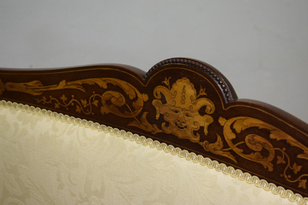 A Victorian dark mahogany settee with floral marquetry inlay along the crest rail and cream damask upholstered seat and backrest. View XVII
