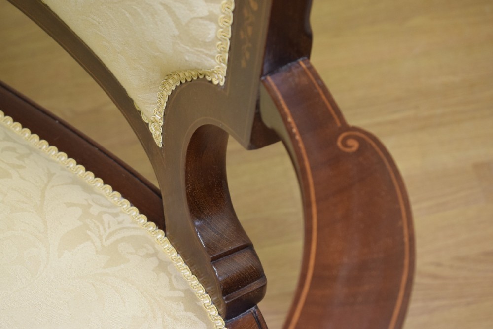 A Victorian dark mahogany settee with floral marquetry inlay along the crest rail and cream damask upholstered seat and backrest. View XVIII