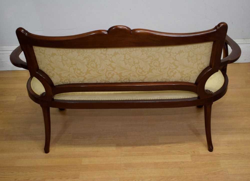 A Victorian dark mahogany settee with floral marquetry inlay along the crest rail and cream damask upholstered seat and backrest. View XXIII