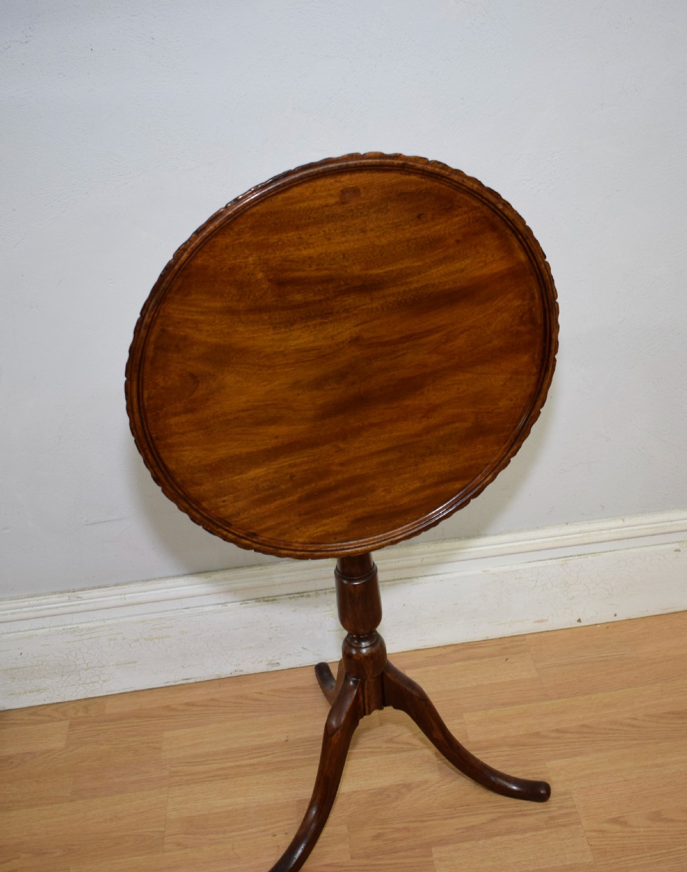 A dark mahogany Georgian tripod table featuring a circular top with a moulded rim, a turned central stem, and three splayed cabriole legs. View IV
