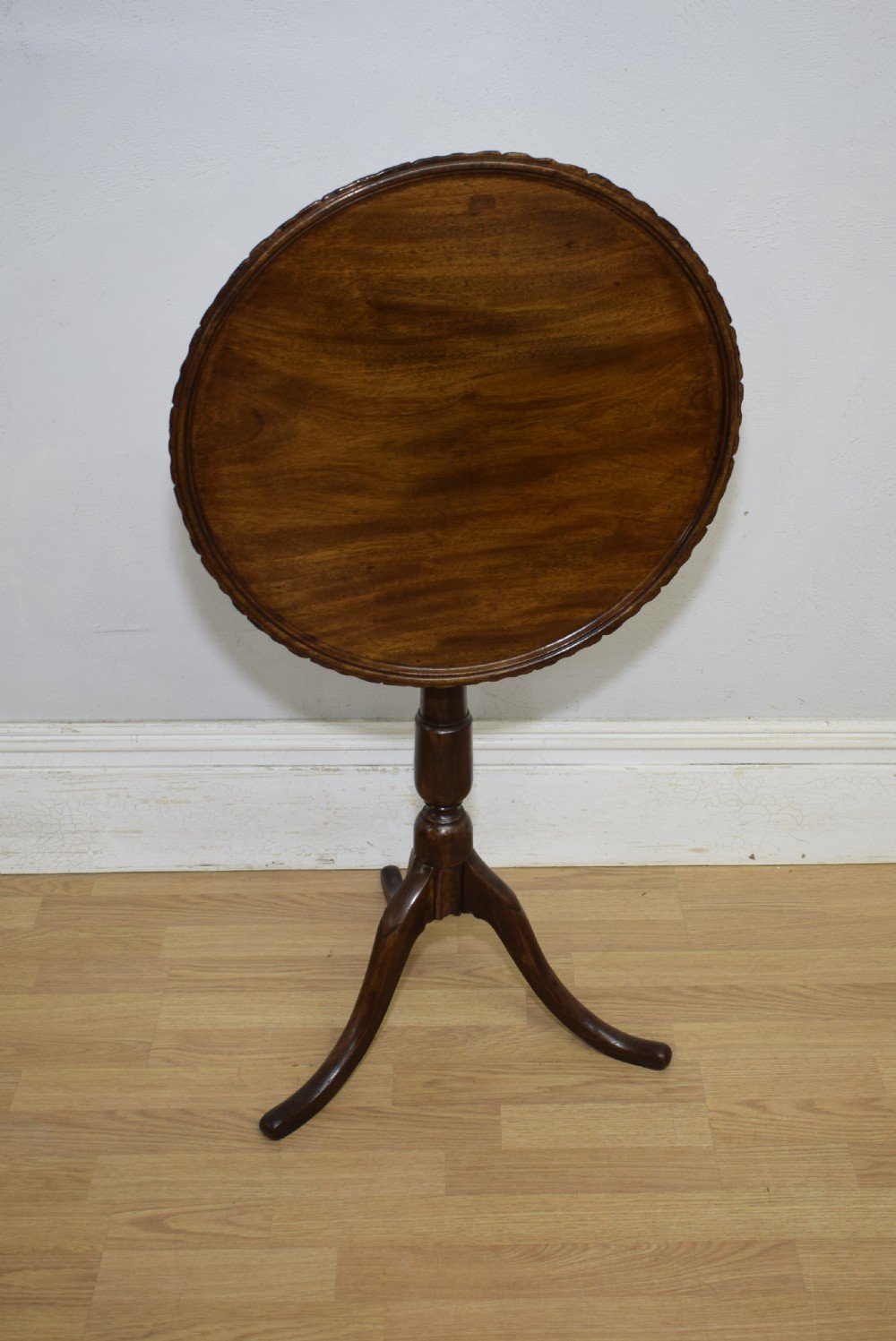 A dark mahogany Georgian tripod table featuring a circular top with a moulded rim, a turned central stem, and three splayed cabriole legs. View V