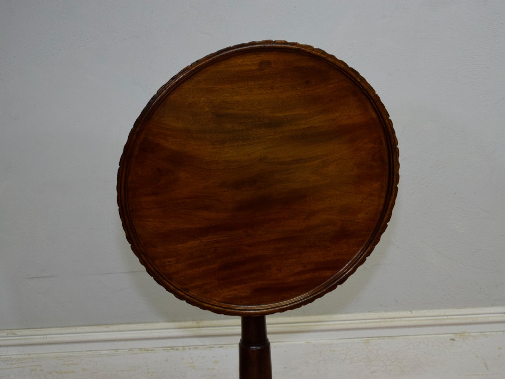 A dark mahogany Georgian tripod table featuring a circular top with a moulded rim, a turned central stem, and three splayed cabriole legs. View VII