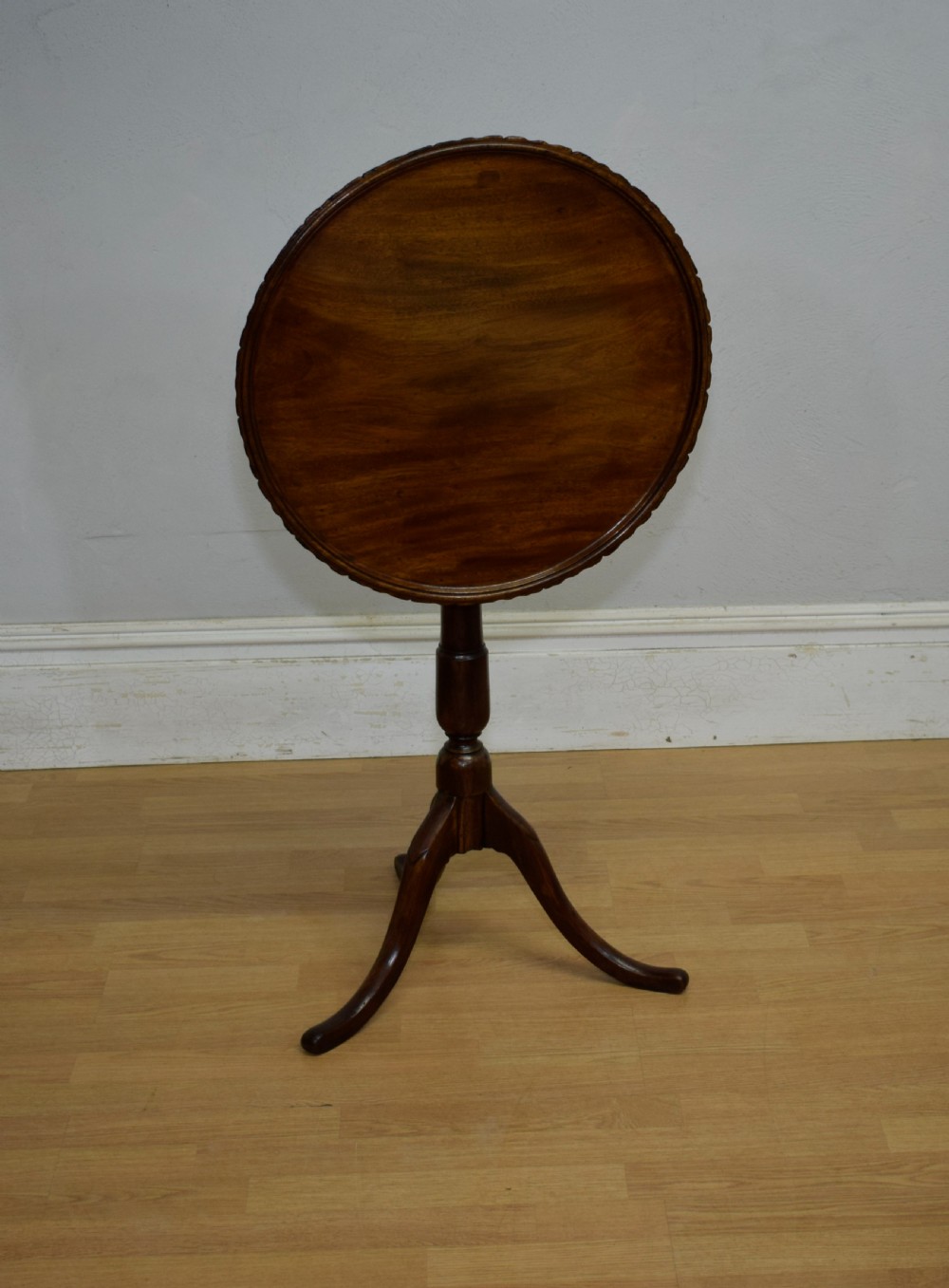 A dark mahogany Georgian tripod table featuring a circular top with a moulded rim, a turned central stem, and three splayed cabriole legs. View IX