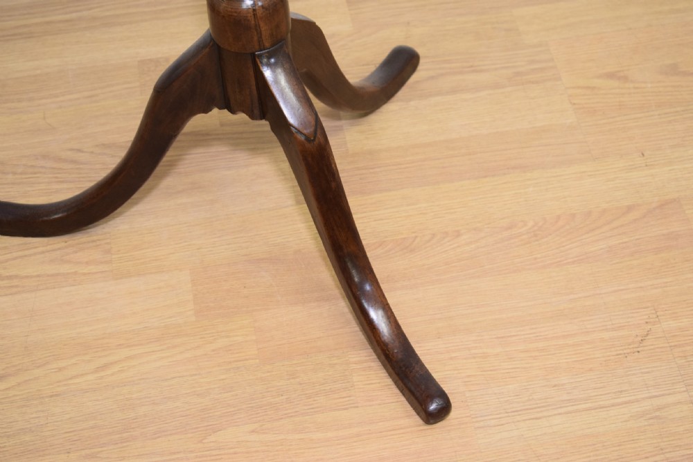 A dark mahogany Georgian tripod table featuring a circular top with a moulded rim, a turned central stem, and three splayed cabriole legs. View XII
