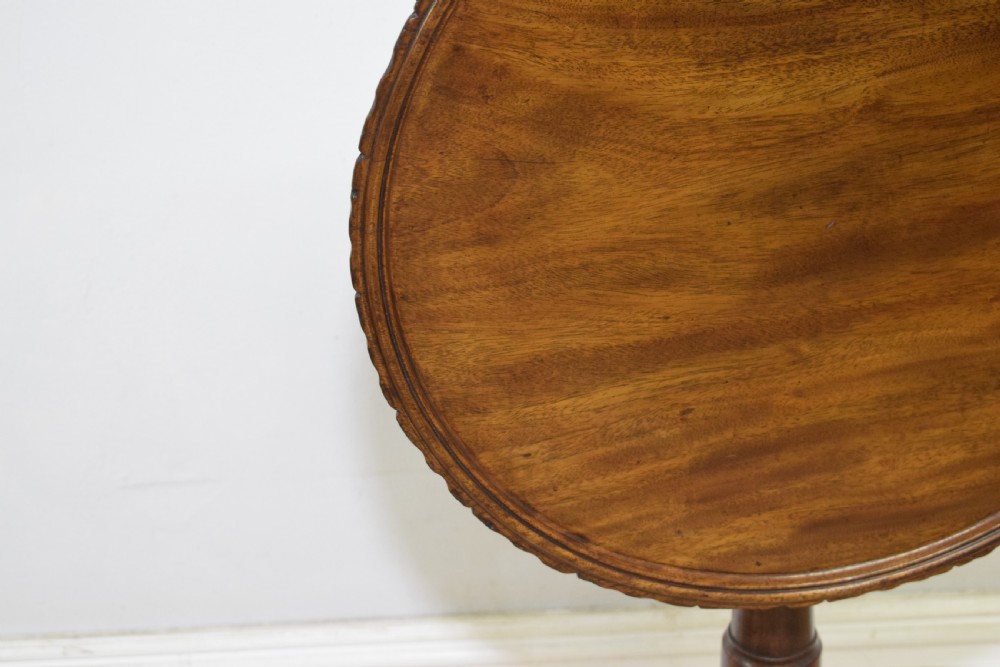 A dark mahogany Georgian tripod table featuring a circular top with a moulded rim, a turned central stem, and three splayed cabriole legs. View XVIII