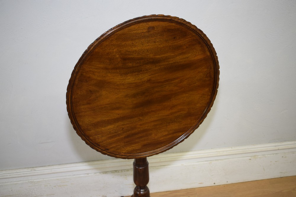 A dark mahogany Georgian tripod table featuring a circular top with a moulded rim, a turned central stem, and three splayed cabriole legs. View XIX