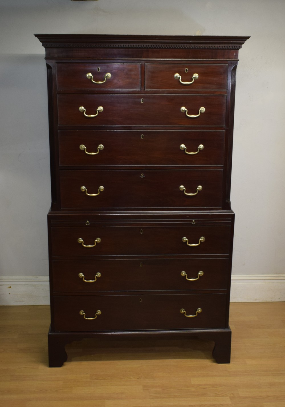 A Georgian mahogany chest on chest featuring two short over six long drawers with brass drop handles and fluted side columns on bracket feet. View V