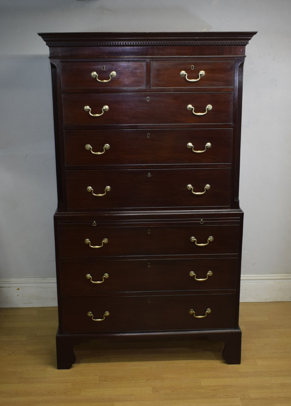 A Georgian mahogany chest on chest featuring two short over six long drawers with brass drop handles and fluted side columns on bracket feet. View VIII