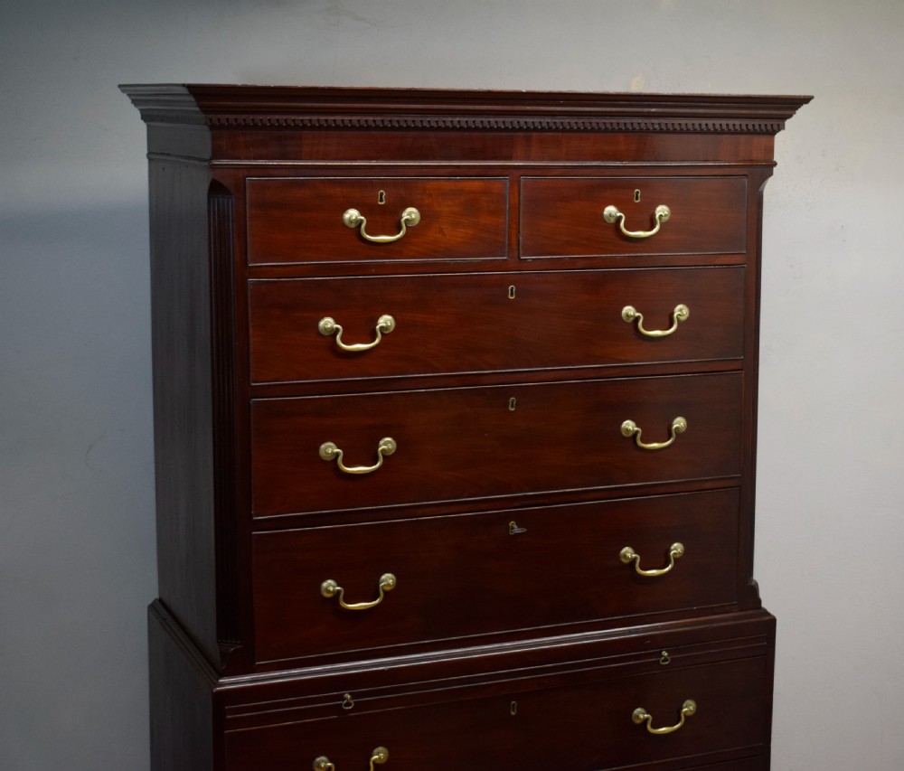 A Georgian mahogany chest on chest featuring two short over six long drawers with brass drop handles and fluted side columns on bracket feet. View XII