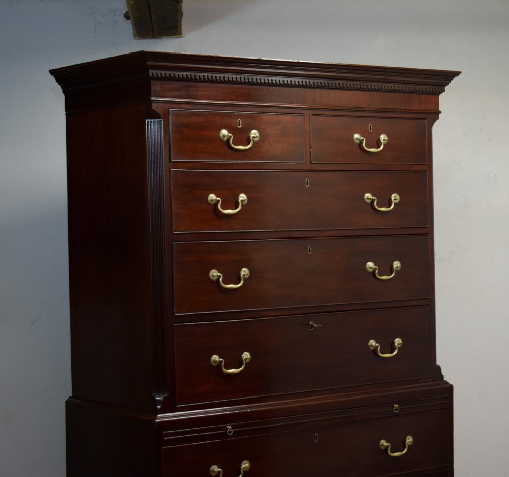 A Georgian mahogany chest on chest featuring two short over six long drawers with brass drop handles and fluted side columns on bracket feet. View XVI