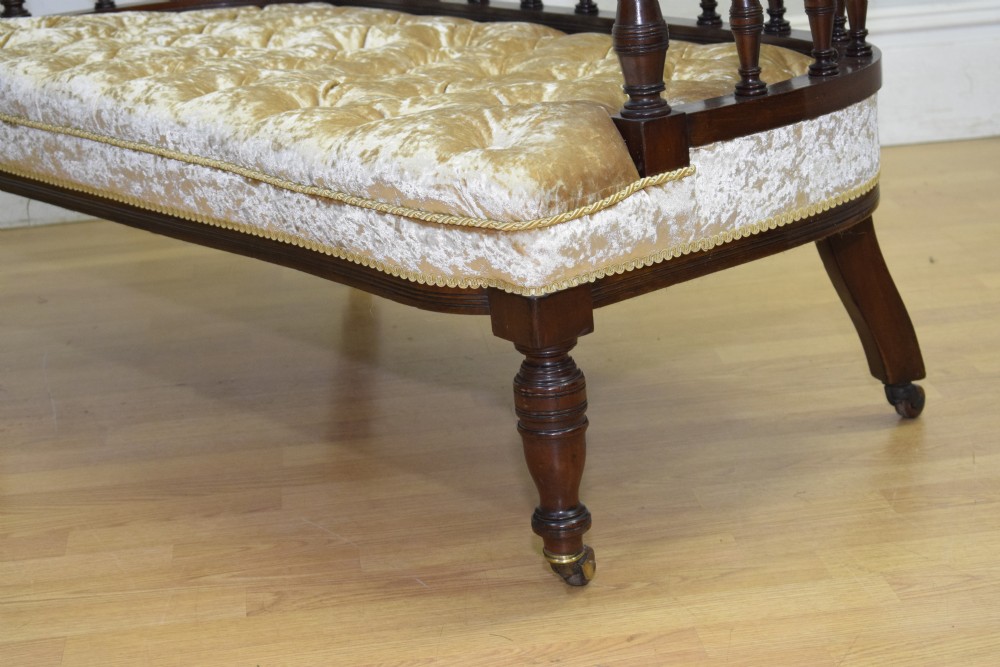 A Victorian mahogany settee with champagne gold crushed velvet deep-buttoned upholstery, a spindle gallery back, and turned legs with castors. View XIV