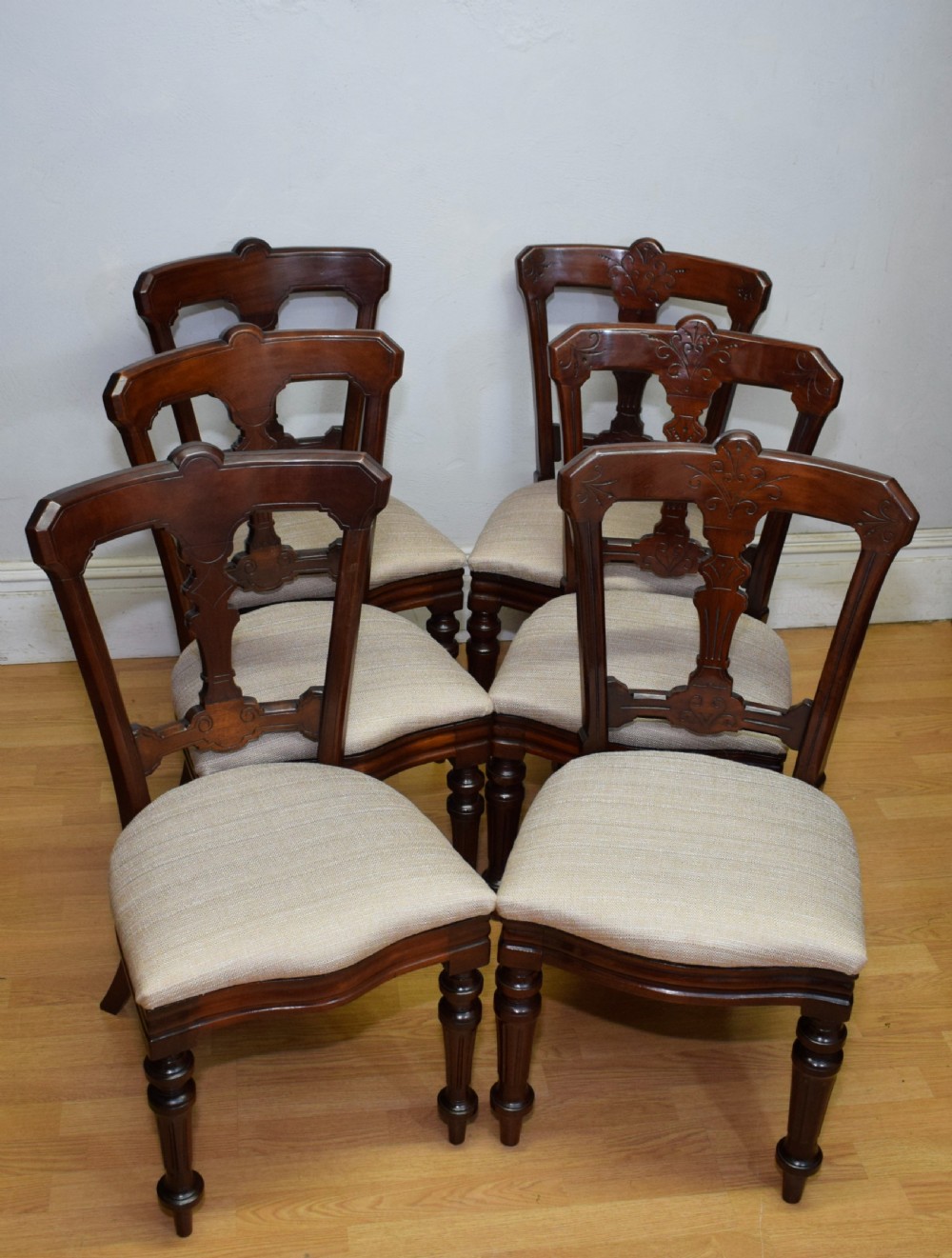 A set of six Victorian mahogany dining chairs featuring carved open backs, turned front legs, and neutral upholstered seats. View II