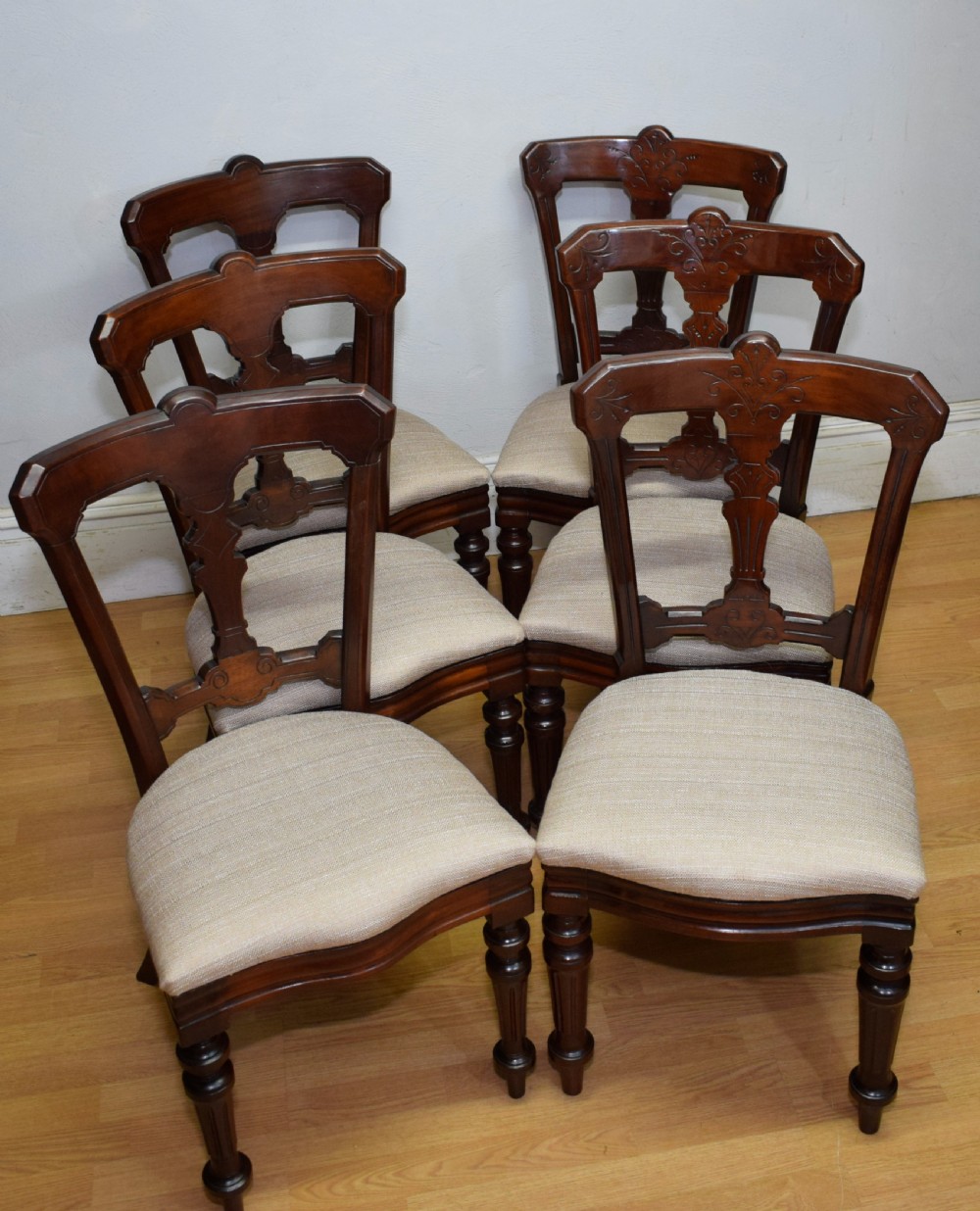 A set of six Victorian mahogany dining chairs featuring carved open backs, turned front legs, and neutral upholstered seats. View III