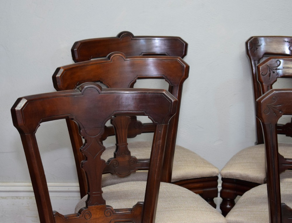 A set of six Victorian mahogany dining chairs featuring carved open backs, turned front legs, and neutral upholstered seats. View VIII