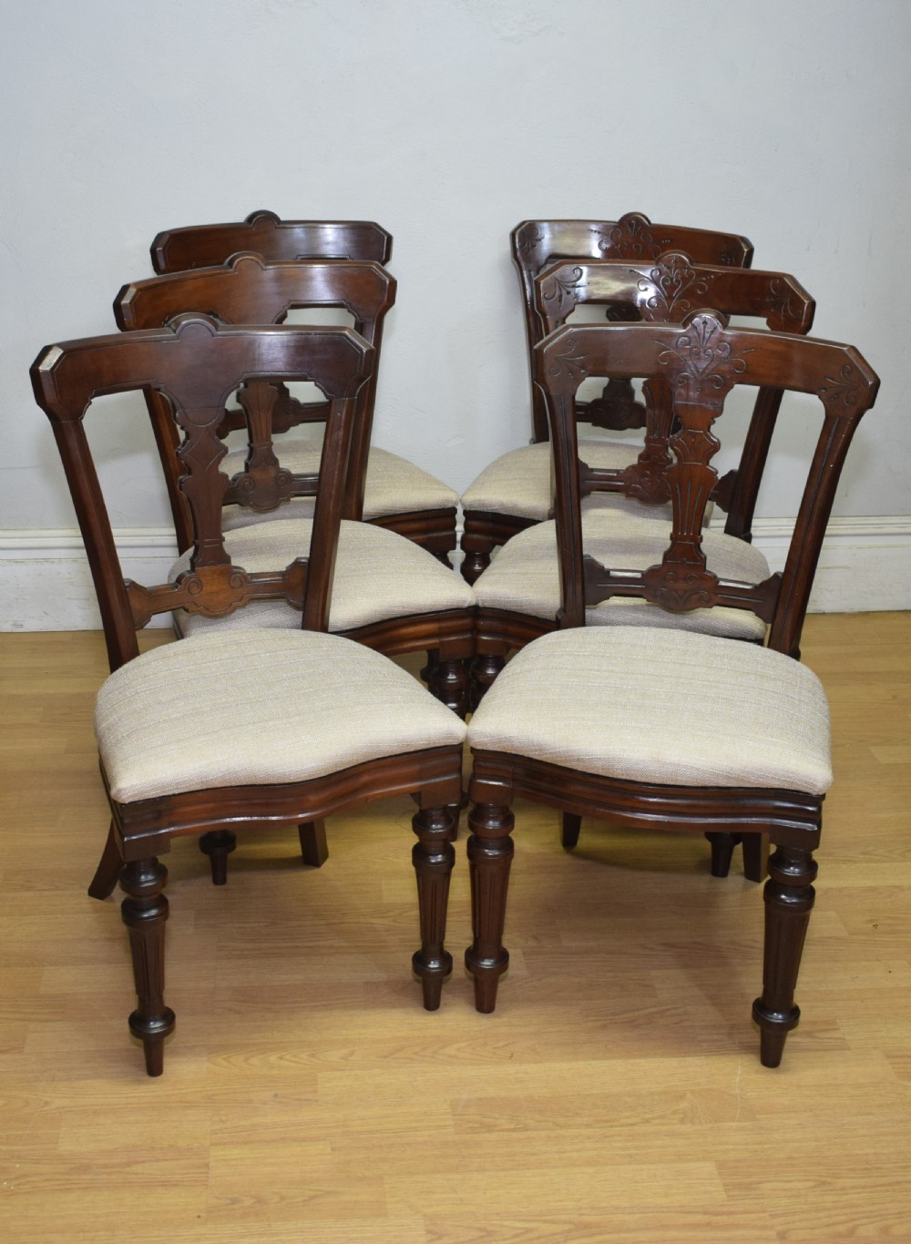 A set of six Victorian mahogany dining chairs featuring carved open backs, turned front legs, and neutral upholstered seats. View IX