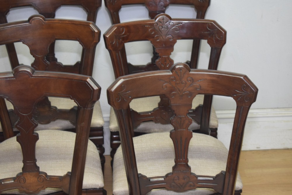 A set of six Victorian mahogany dining chairs featuring carved open backs, turned front legs, and neutral upholstered seats. View XIV