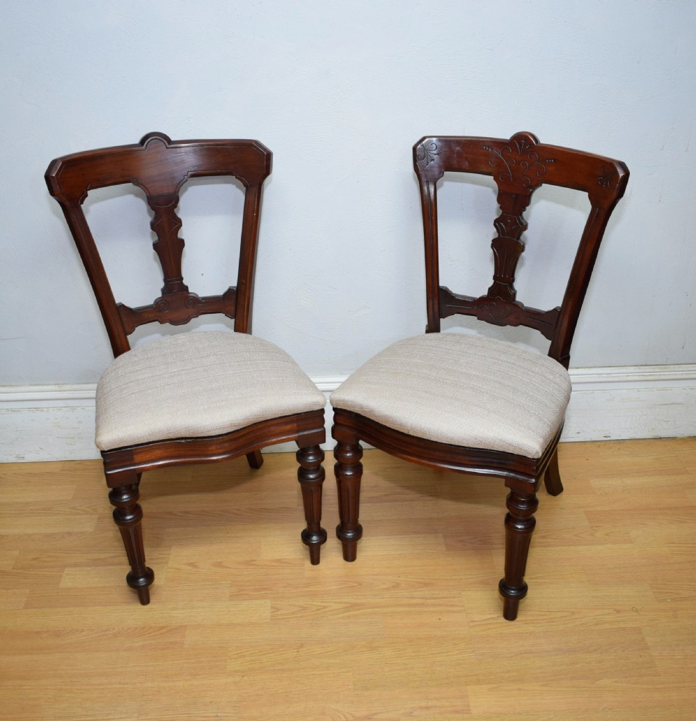 A set of six Victorian mahogany dining chairs featuring carved open backs, turned front legs, and neutral upholstered seats. View XIX