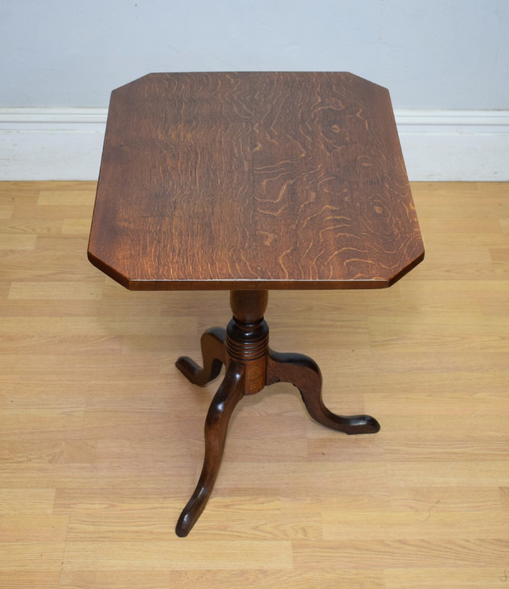 A Georgian oak tripod table with a rectangular top featuring canted corners, a turned pedestal stem, and three downswept legs.