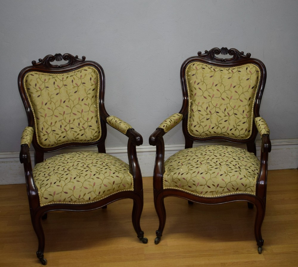 A pair of 19th-century French armchairs featuring carved dark wood frames, cabriole legs with castors, and light green embroidered fabric upholstery. View IV