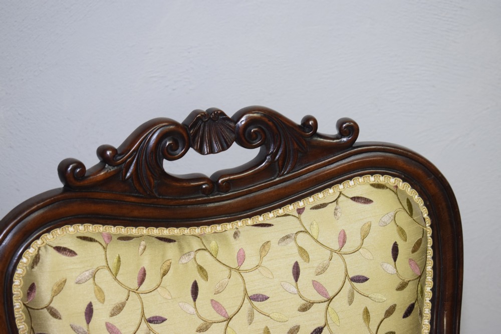 A pair of 19th-century French armchairs featuring carved dark wood frames, cabriole legs with castors, and light green embroidered fabric upholstery. View VII