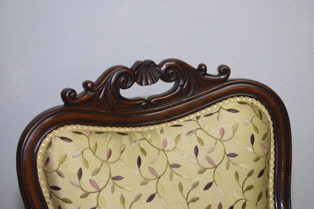 A pair of 19th-century French armchairs featuring carved dark wood frames, cabriole legs with castors, and light green embroidered fabric upholstery. View IX