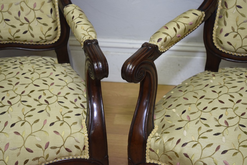 A pair of 19th-century French armchairs featuring carved dark wood frames, cabriole legs with castors, and light green embroidered fabric upholstery. View XII