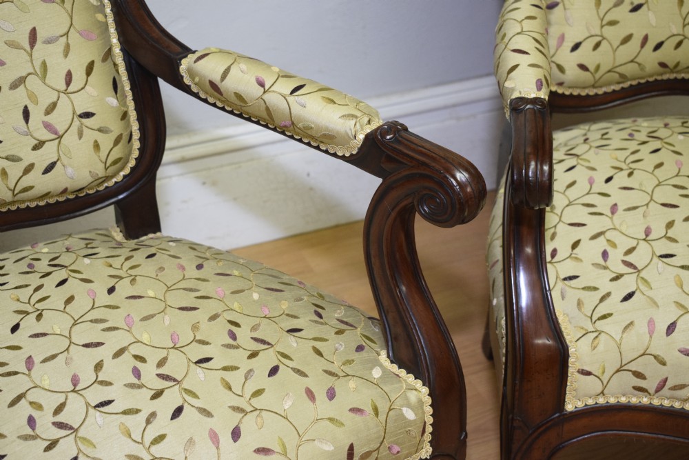 A pair of 19th-century French armchairs featuring carved dark wood frames, cabriole legs with castors, and light green embroidered fabric upholstery. View XIV