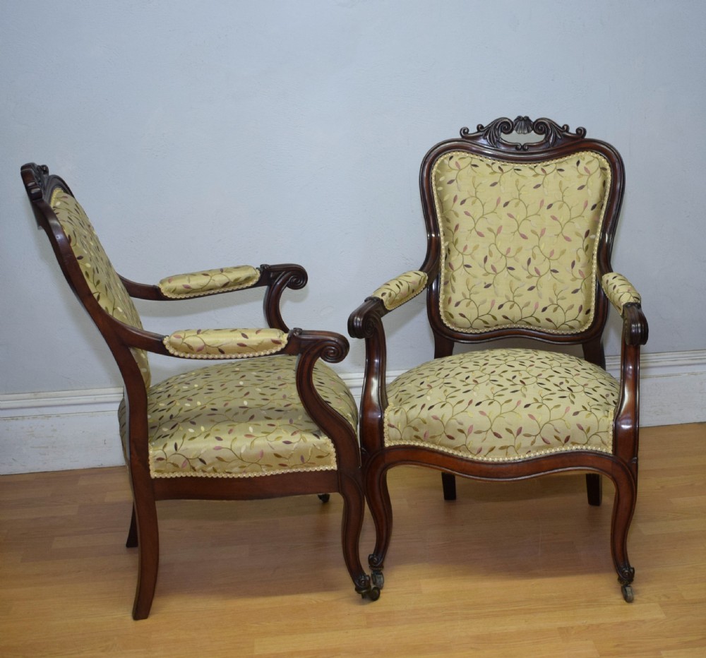A pair of 19th-century French armchairs featuring carved dark wood frames, cabriole legs with castors, and light green embroidered fabric upholstery. View XV