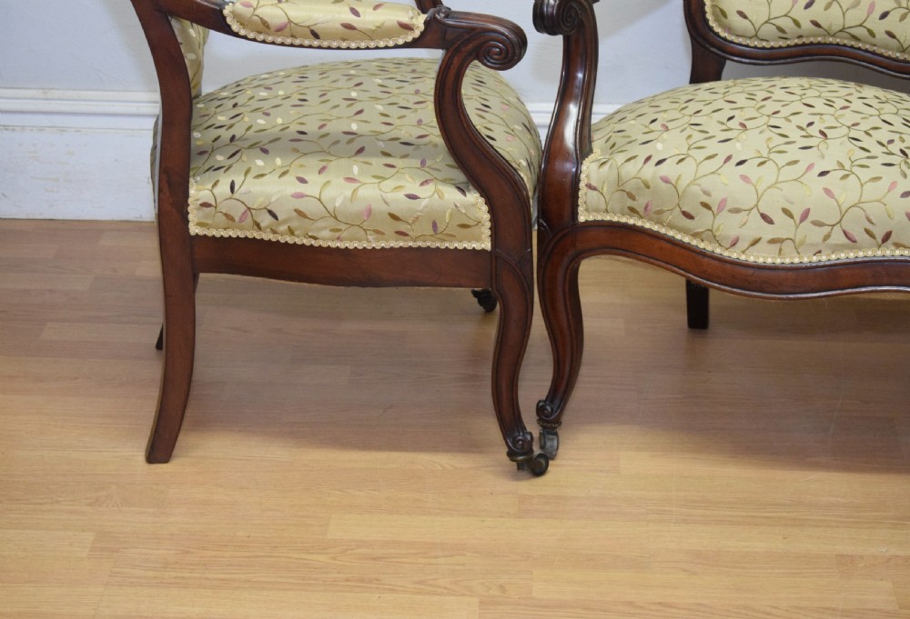 A pair of 19th-century French armchairs featuring carved dark wood frames, cabriole legs with castors, and light green embroidered fabric upholstery. View XVI