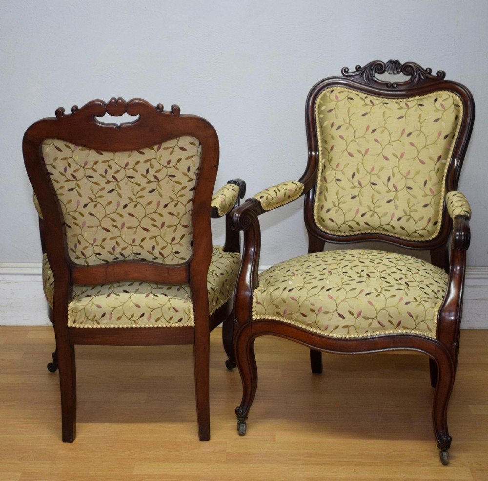 A pair of 19th-century French armchairs featuring carved dark wood frames, cabriole legs with castors, and light green embroidered fabric upholstery. View XXI