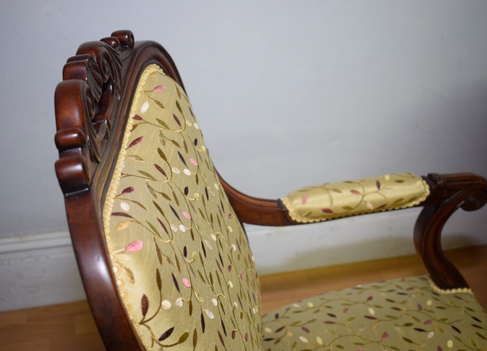 A pair of 19th-century French armchairs featuring carved dark wood frames, cabriole legs with castors, and light green embroidered fabric upholstery. View XXIV