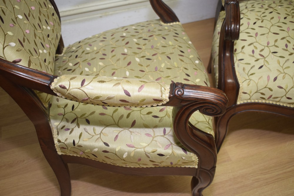 A pair of 19th-century French armchairs featuring carved dark wood frames, cabriole legs with castors, and light green embroidered fabric upholstery. View XXV