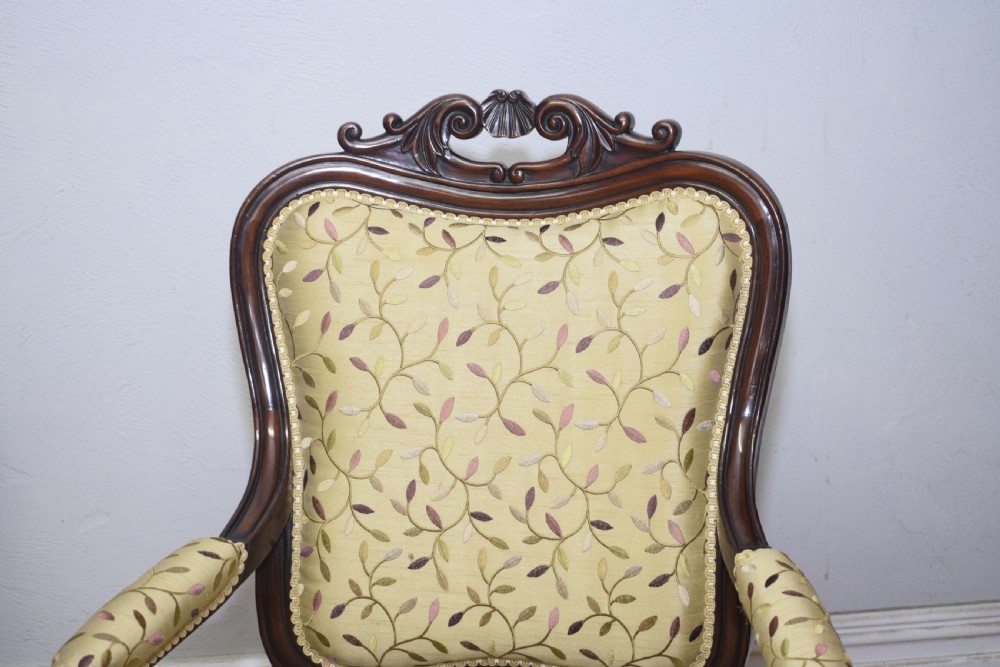 A pair of 19th-century French armchairs featuring carved dark wood frames, cabriole legs with castors, and light green embroidered fabric upholstery. View XXVII