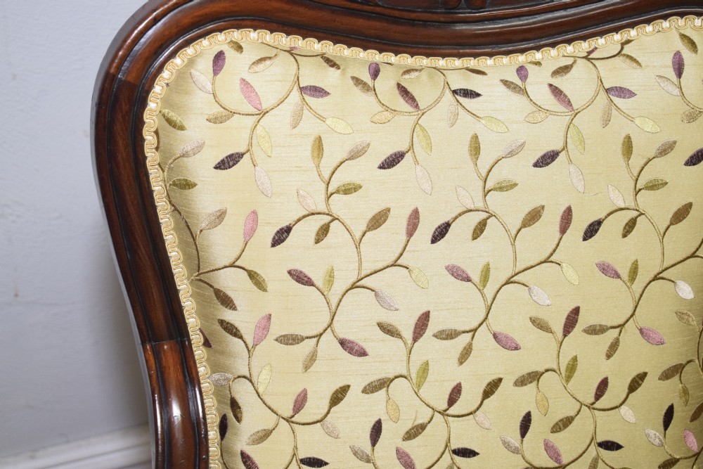 A pair of 19th-century French armchairs featuring carved dark wood frames, cabriole legs with castors, and light green embroidered fabric upholstery. View XXVIII