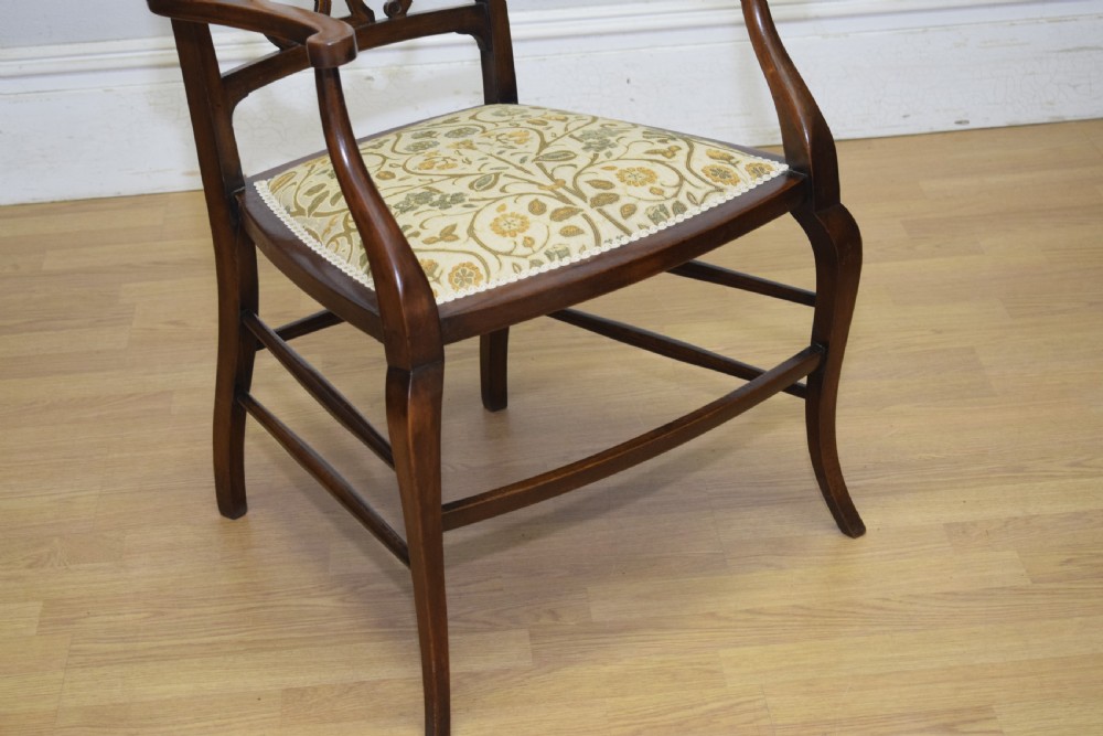 An Edwardian mahogany open armchair featuring a carved splat back, shaped armrests, and floral pattern fabric upholstery. View VIII