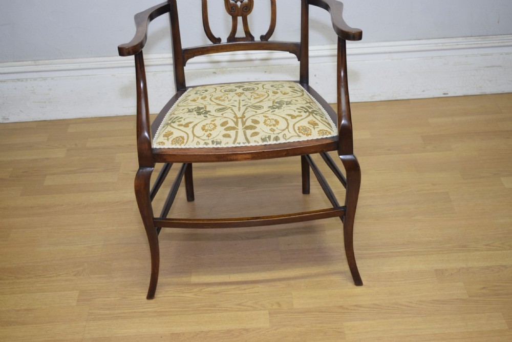 An Edwardian mahogany open armchair featuring a carved splat back, shaped armrests, and floral pattern fabric upholstery. View XI