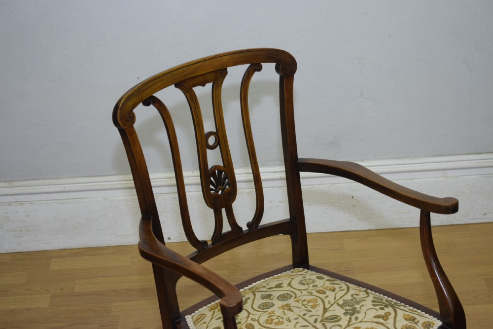 An Edwardian mahogany open armchair featuring a carved splat back, shaped armrests, and floral pattern fabric upholstery. View XII