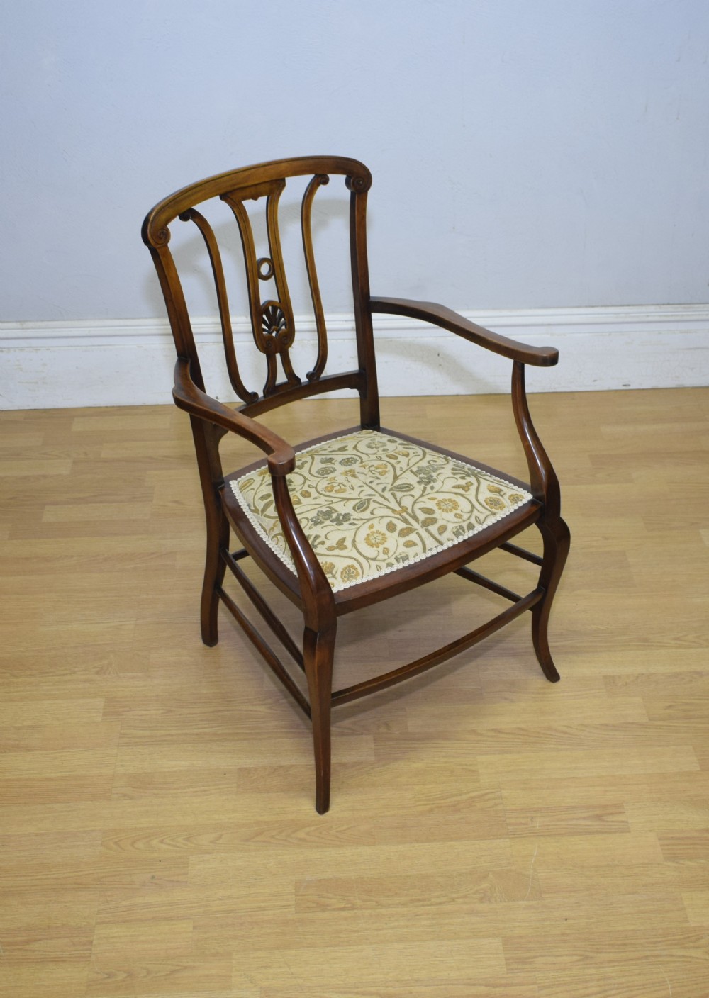 An Edwardian mahogany open armchair featuring a carved splat back, shaped armrests, and floral pattern fabric upholstery. View XIV