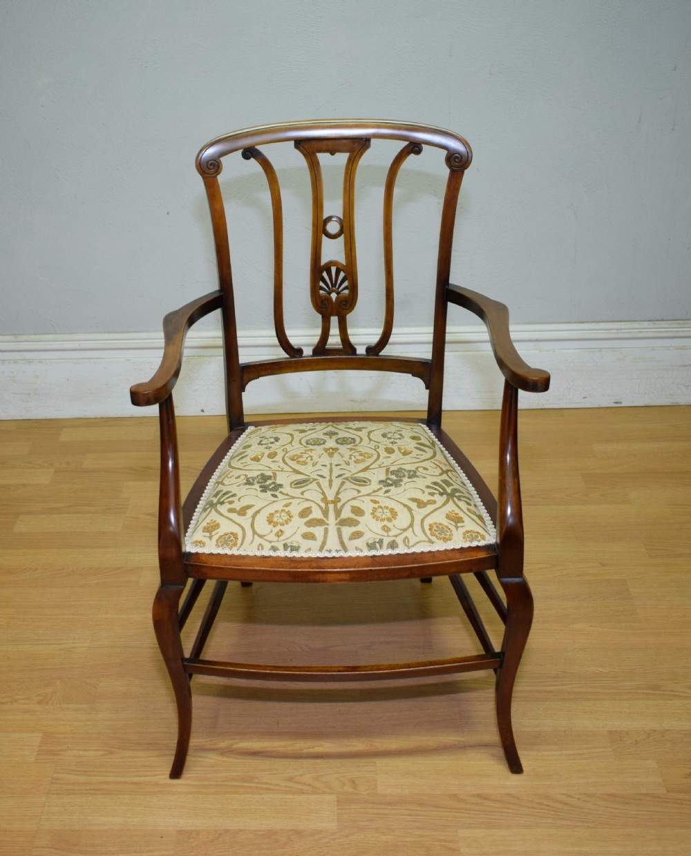 An Edwardian mahogany open armchair featuring a carved splat back, shaped armrests, and floral pattern fabric upholstery. View XVII
