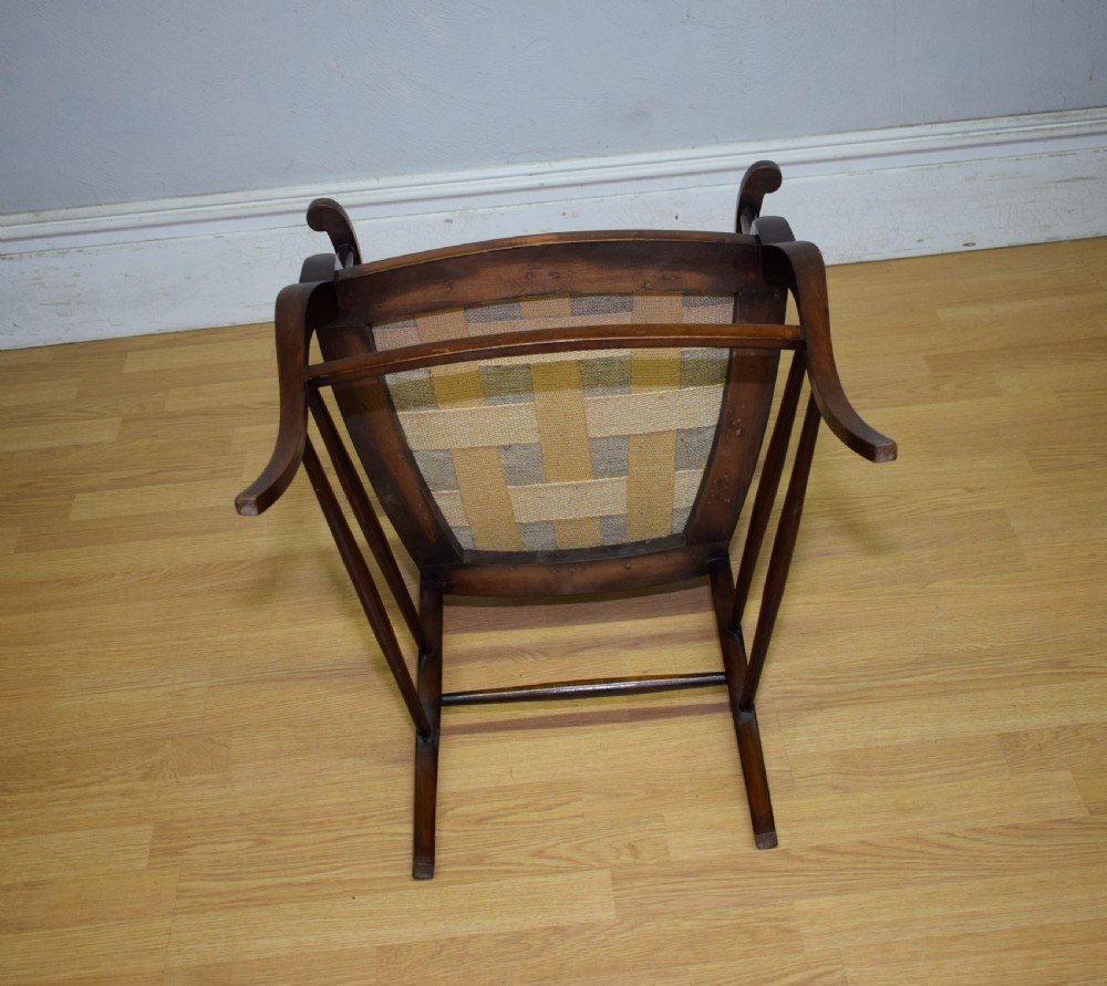 An Edwardian mahogany open armchair featuring a carved splat back, shaped armrests, and floral pattern fabric upholstery. View XVIII