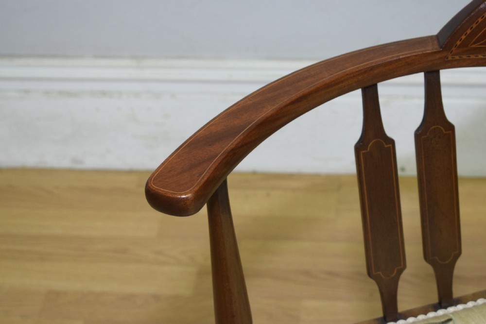 An Edwardian mahogany corner chair featuring a curved top rail with fan inlay, turned spindles, and a floral upholstered square seat. View XI