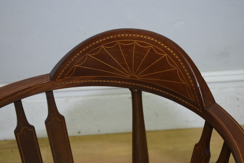An Edwardian mahogany corner chair featuring a curved top rail with fan inlay, turned spindles, and a floral upholstered square seat. View XII