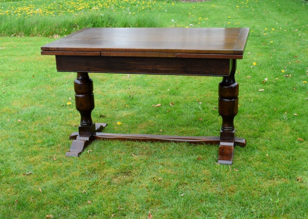 An early 20th-century dark oak refectory dining table featuring turned bulbous legs, a low central stretcher, and a rectangular wooden top. View II