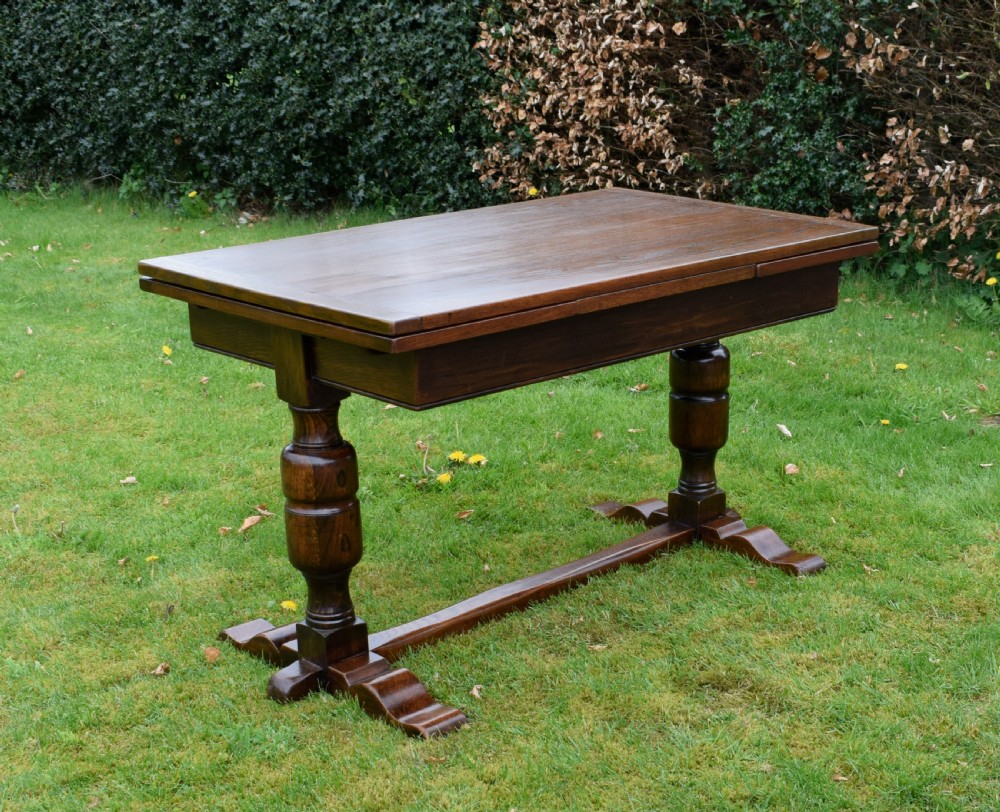 An early 20th-century dark oak refectory dining table featuring turned bulbous legs, a low central stretcher, and a rectangular wooden top. View III