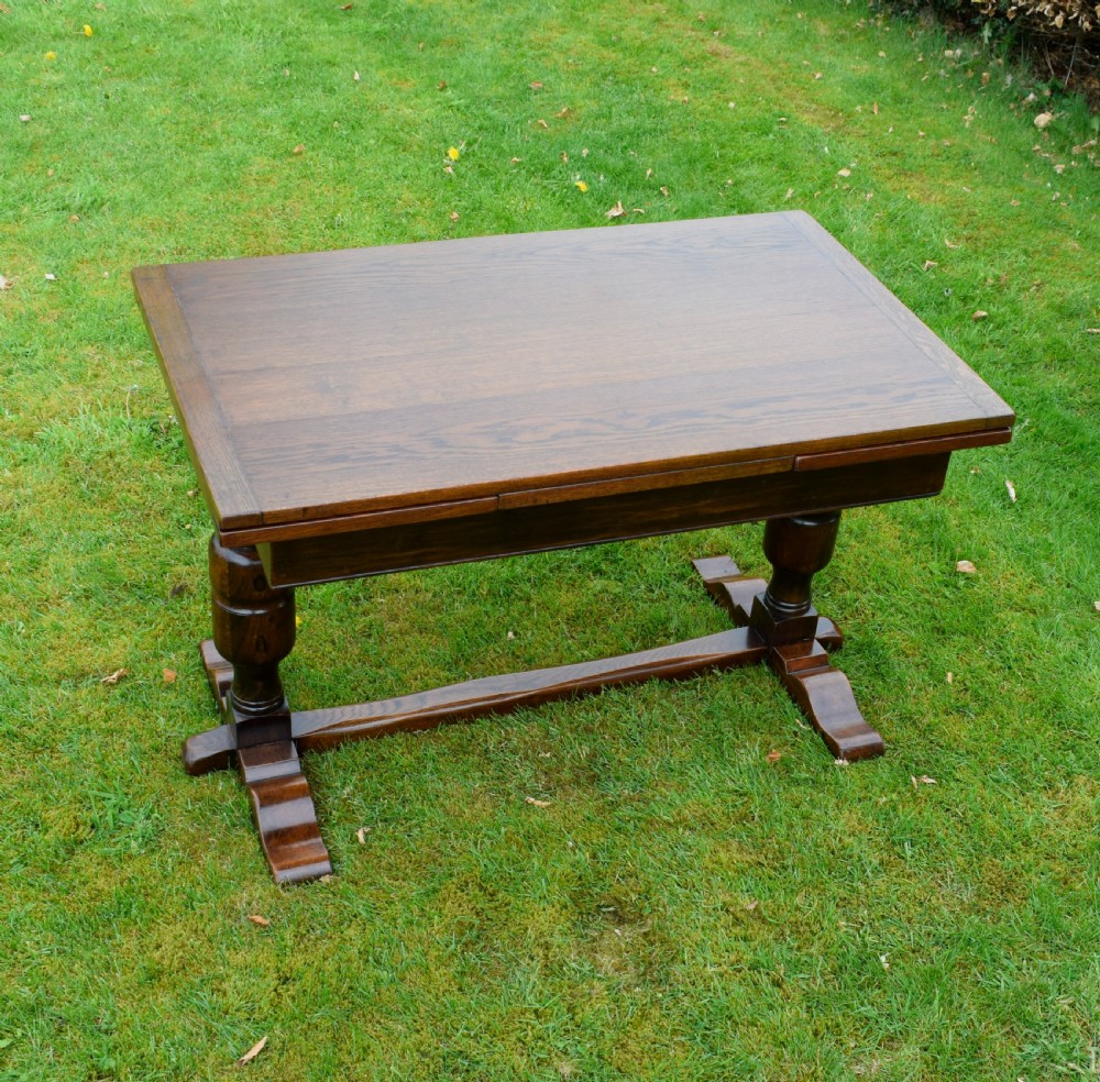 An early 20th-century dark oak refectory dining table featuring turned bulbous legs, a low central stretcher, and a rectangular wooden top. View V