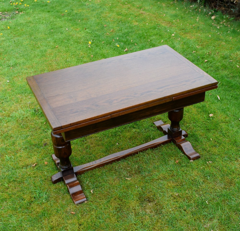 An early 20th-century dark oak refectory dining table featuring turned bulbous legs, a low central stretcher, and a rectangular wooden top. View VI