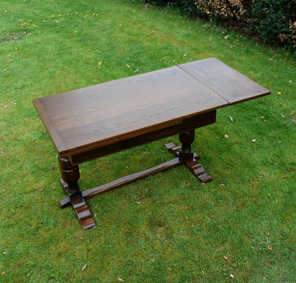 An early 20th-century dark oak refectory dining table featuring turned bulbous legs, a low central stretcher, and a rectangular wooden top. View VII