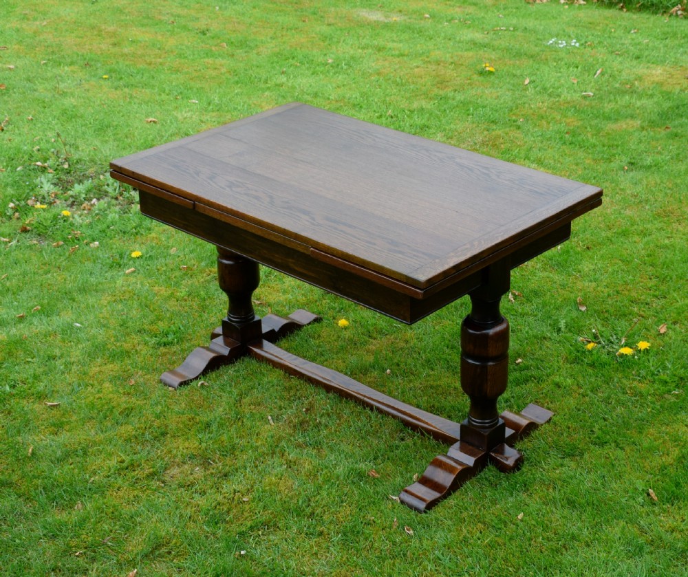 An early 20th-century dark oak refectory dining table featuring turned bulbous legs, a low central stretcher, and a rectangular wooden top. View VIII