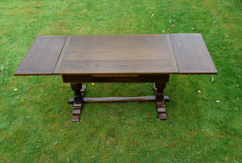 An early 20th-century dark oak refectory dining table featuring turned bulbous legs, a low central stretcher, and a rectangular wooden top. View IX