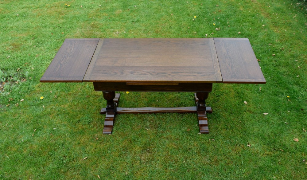 An early 20th-century dark oak refectory dining table featuring turned bulbous legs, a low central stretcher, and a rectangular wooden top. View X